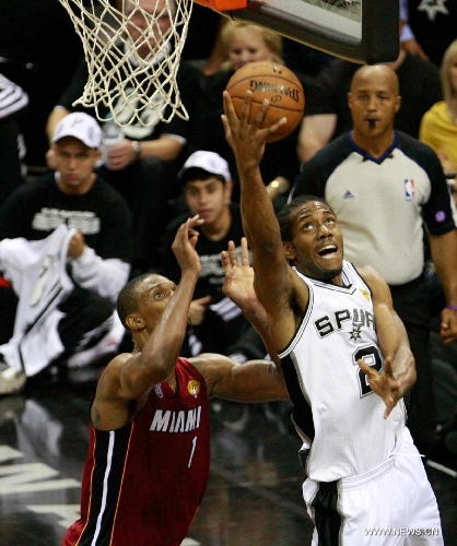 San Antonio Spurs Kawhi Leonard (R) goes to the basket during the Game 3 of the 2013 NBA Finals against Miami Heat in San Antonio, Texas, the United States, June 11, 2013. San Antonio Spurs won 113-77. (Xinhua/Song Qiong)