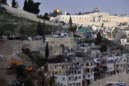 An Israeli army bulldozer uproots trees in the eastern Jerusalem's Arab neighbourhood of Silwan on Jan. 28, 2013. Nine people were injured and seven arrested in Silwan after clashes broke out as Israeli forces demolished several structures on Monday. (Xinhua/Muamar Awad) 