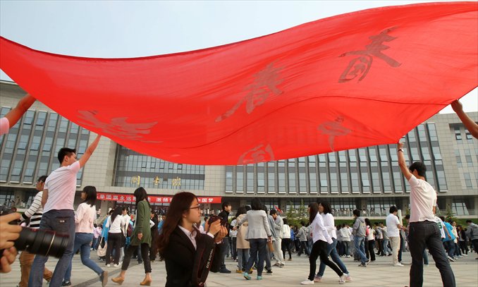 Students at Nantong University in Jiangsu Province carry a banner with signs showing 