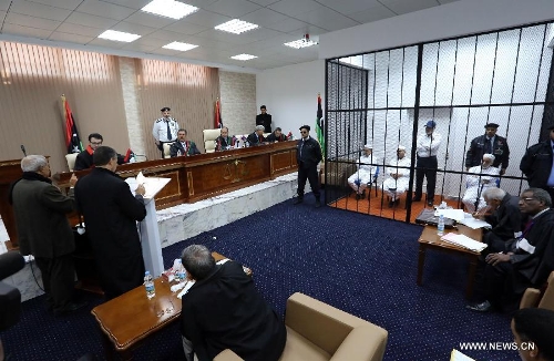 Former Libyan Prime Minister Baghdadi al-Mahmoudi sits in a cage during his trial at a court in Tripoli, capital of Libya, on Jan. 14, 2013. The trial of former Prime Minister Baghdadi al-Mahmoudi started here on Monday. Mahmoudi, who served as the last prime minister in former leader Muammar Gaddafi's administration from 2006 to 2011, fled to Tunisia in September 2011 after the armed rebels seized the Libyan capital of Tripoli during the unrest. (Xinhua/Hamza Turkia) 