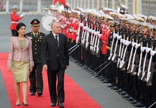 Thai Prime Minister Yingluck Shinawatra (L front) and French Prime Minister Jean-Marc Ayrault (R front) review the guard of honor during a welcoming ceremony at the Government House in Bangkok, capital of Thailand, Feb. 5, 2013. (Xinhua/Gao Jianjun) 