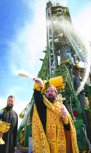 A Russian Orthodox priest blesses an audience near a Russian Soyuz-FG rocket with Soyuz TMA-10M spacecraft aboard at the launch pad of the Russian leased Kazakhstan's Baikonur cosmodrome on Monday. The Soyuz TMA-10M will transport the Expedition 37 crew to the International Space Station on Thursday. Photo: CFP