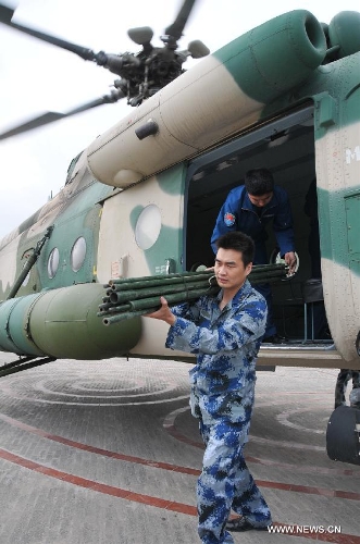 &nbsp;&nbsp;Members of the People's Liberation Army Air Force (PLAAF) unload relief materia from a military helicopter at Lushan County in quake-hit Ya'an, southwest China's Sichuan Province, April 20, 2013. As of 4:00 p.m. Beijing time (GMT 0800), the PLAAF deployed 10 sorties of transport planes and helicopters for various rescue and relief work, including aerial photography, transporting and disaster situation reconnaissance.(Xinhua/Huang Shubo)