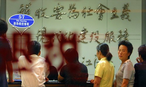 Taxpayers queue in front of a counter to deal with paperwork at a taxation bureau in Nanjing, Jiangsu Province on August 29, 2005. Photo: CFP