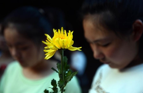 &nbsp; People hold flowers to mourn the death of Wang Jialin and Ye Mengyuan, two young girls killed in a crash landing of an Asiana Airlines Boeing 777 at San Francisco airport, in Jiangshan City, east China's Zhejiang Province, July 8, 2013. Local residents gathered at Xujiang Park in Jiangshan to show their grief to the 17-year-old Wang and 16-year-old Ye, who were students from Jiangshan High School. (Xinhua/Han Chuanhao)