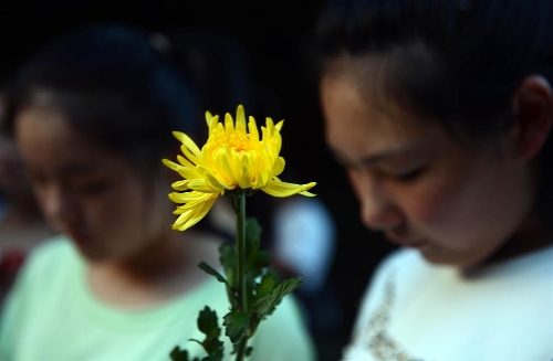   People hold flowers to mourn the death of Wang Jialin and Ye Mengyuan, two young girls killed in a crash landing of an Asiana Airlines Boeing 777 at San Francisco airport, in Jiangshan City, east China's Zhejiang Province, July 8, 2013. Local residents gathered at Xujiang Park in Jiangshan to show their grief to the 17-year-old Wang and 16-year-old Ye, who were students from Jiangshan High School. (Xinhua/Han Chuanhao)