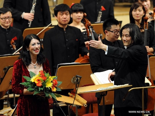 Iris Vermillion (L) and Tang Muhai, conductor of Zhejiang Symphony Orchestra congratulate each other during the conclusion performance of the 2012 China Cultural Year in Germany, at the Concert Hall in Berlin, Germany, Jan. 13, 2013. (Xinhua/Wang Xiaochuan)&nbsp; 