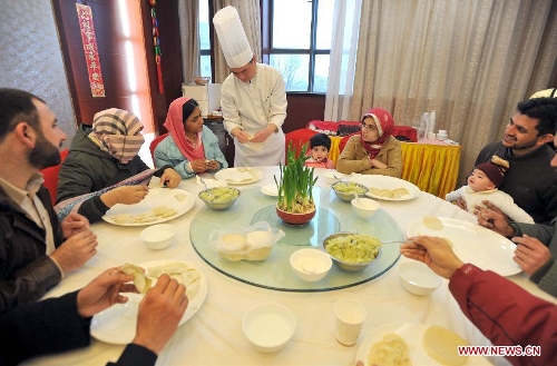 A chef teaches overseas students to make dumplings in an activity to celebrate the Chinese New Year at the Nanjing Agricultural University in Nanjing, capital of east China's Jiangsu Province, Feb. 4, 2013. More than 50 overseas students from over 20 countries and regions experienced Chinese traditional cultural activities with local students. (Xinhua)  