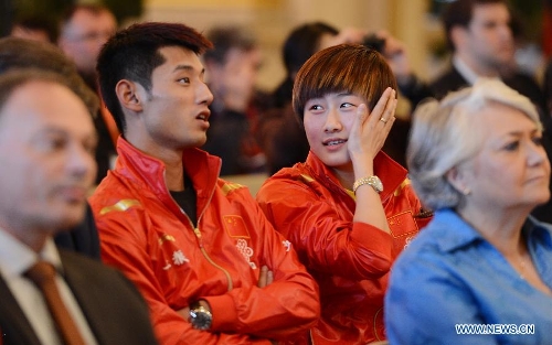 Chinese player Ding Ning (R) talks with her compatriot Zhang Jike during the official draw of the upcoming World Table Tennis Championships in Paris, France, May 11, 2013. The world championships will kick off on May 13 and the final event will be held on May 20. (Xinhua/Tao Xiyi) 