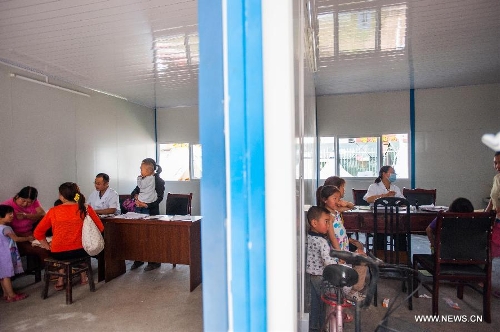 People see a doctor in a temporarily-erected prefabricated house at the People's Hospital in Lushan County, southwest China's Sichuan Province, May 12, 2013. Eight prefabricated houses have been built here to provide medical services to residents. The county was jolted by a 7.0-magnitude earthquake on April 20. (Xinhua/Li Hualiang) 