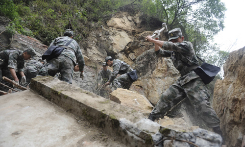 Soldiers from the People's Liberation Army (PLA) Chengdu Military Area Command (MAC) clear a path in Baoxing county, which was cut off by a landslide on April 23. Photo: Li Hao/GT