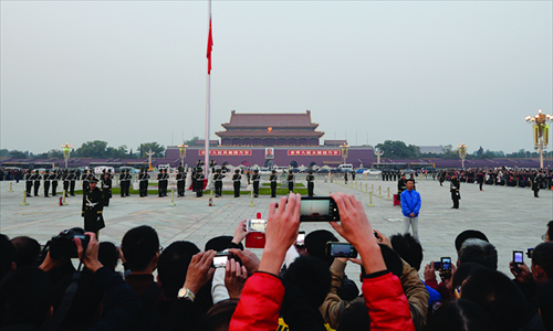 Crowds watch a flag-lowering ceremony at Tiananmen Square on Friday, one day before the convening of the Third Plenum of the 18th Communist Party of China Central Committee in Beijing. Photo: AFP