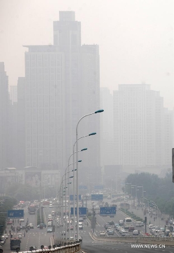 Fog-shrouded buildings are pictured in Tianjin, north China, June 18, 2013. Local meteorological authorities issued a yellow fog alert on Tuesday morning. (Xinhua/Liu Dongyue)