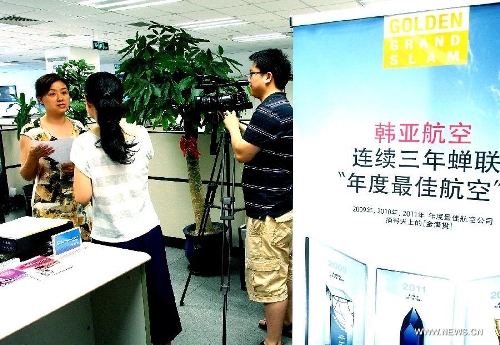 An employee is interviewed by reporters at the office of the Asiana Airlines to Shanghai, east China, July 7, 2013. A total of 141 Chinese citizens were among the 291 passengers aboard the Asiana Airlines flight that crash-landed at the San Francisco International Airport on Saturday, and 90 of the Chinese passengers in total departed from Shanghai via Seoul to the San Francisco airport in the U.S. All the two killed in the crash were identified to be Chinese women, South Korea's transportation ministry said Sunday. (Xinhua/Chen Fei)&nbsp; 