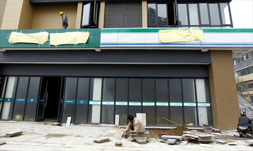 A construction crew works on imitation Starbucks and FamilyMart stores at a residential complex in Jiading district. District authorities ordered the complex's developer to cover the stores' signs, which read 