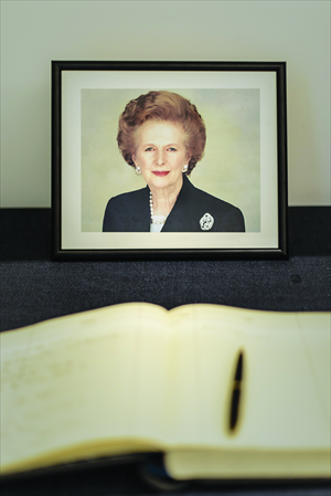 A portrait of Margaret Thatcher sits next to a condolence book at the British consulate in Hong Kong on Tuesday. She died on Monday following a stroke at the age of 87. Photo: AFP