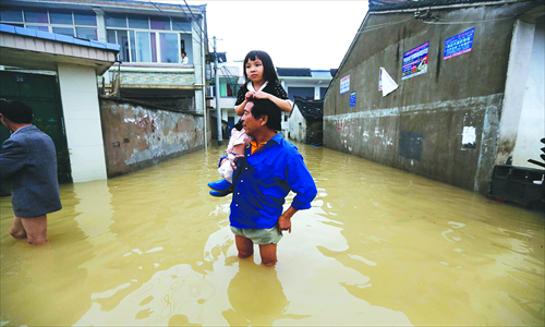 A father carries his daughter through a flood-hit street in Yuyao, Zhejiang Province, October 9. Photo: Yang Hui/GT