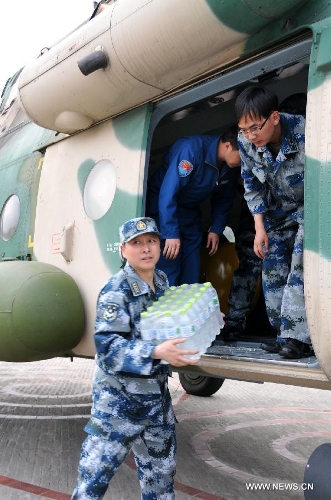 Members of the People's Liberation Army Air Force (PLAAF) unload relief materials from a military helicopter at Lushan County in quake-hit Ya'an, southwest China's Sichuan Province, April 20, 2013. As of 4:00 p.m. Beijing time (GMT 0800), the PLAAF deployed 10 sorties of transport planes and helicopters for various rescue and relief work, including aerial photography, transporting and disaster situation reconnaissance.(Xinhua/Huang Shubo)
