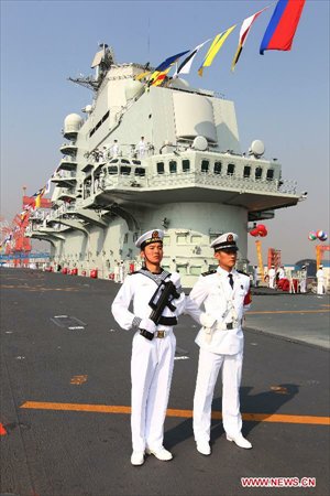 Military officers stand onboard China's aircraft carrier 