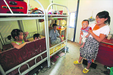 A family of five from Fuyang, Anhui Province, rest from the sweltering noon in a dorm. Due to being the violation of the family planning policy, the parents refused to give their names. Photo: Lu Yun/GT