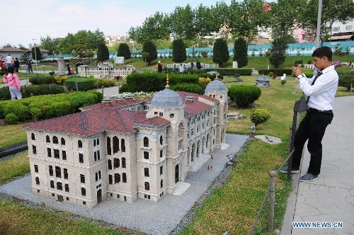A visitor takes photos in front of the miniature of Main Post Office in Sirkeci in the Miniature park in Istanbul, Turkey, on May 11, 2013. The Miniaturk park is the first miniature park in Istanbul and has welcomed 6.5 million visitors over the past 10 years. (Xinhua/Lu Zhe) 