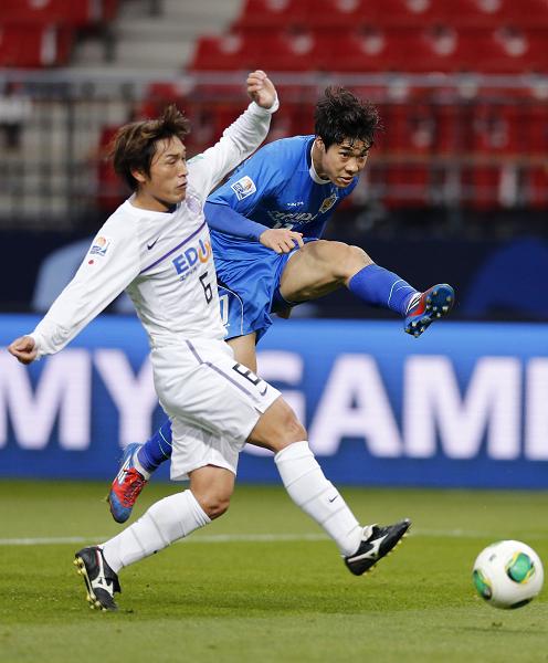 Ulsan Hyundai's Ko Seul-ki (in blue) fights for the ball with Sanfrecce Hiroshima's Toshihiro Aoyama during the fifth place match of the FIFA Club World Cup soccer tournament on Wednesday. Photo: IC