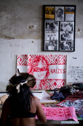 An indigenous woman draws traditional patterns inside the old Indian Museum in Rio de Janeiro, Brazil, Jan. 16, 2013. The government of Rio de Janeiro plans to tear down an old Indian museum beside Maracana Stadium to build parking lot and shopping center here for the upcoming Brazil 2014 FIFA World Cup. The plan met with protest from the indigenous groups. Now Indians from 17 tribes around Brazil settle down in the old building, appealing for the protection of the century-old museum, the oldest Indian museum in Latin America. They hope the government could help renovate it and make part of it a college for indigenous Indians. (Xinhua/Weng Xinyang) 