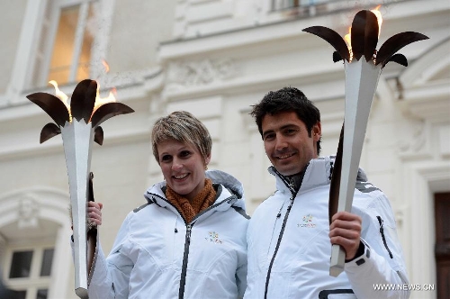 Torch bearers former French biathlete Sandrine Bailly (L) and alpine ski racer Jean-Baptiste Grange pose for pictures before the opening ceremony of 2nd International Military Sports Council(CISM) World Winter Games at Annecy, France, March 25, 2013. (Xinhua/Wang Siwei) 