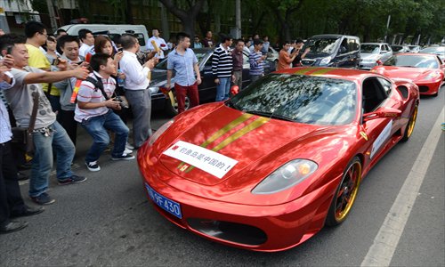 Sports cars bearing anti-Japanese messages drive past the Japanese embassy in Beijing as protests continue over the Diaoyu Islands issue on Thursday. Photo: AFP