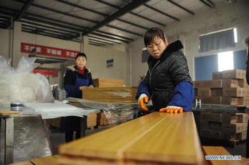 Workers manufacture bamboo floor boards in a company of Nanchang County, East China's Jiangxi Province, March 15, 2012. Photo: Xinhua