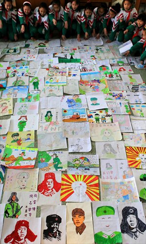 Pupils of a primary school in Xuchang, Henan Province paint portraits and images of Lei Feng helping others on Monday. Tuesday is the annual Lei Feng Day, which is dedicated to the memory of the selfless, patriotic hero who devoted his short life to helping others. Photo: CFP