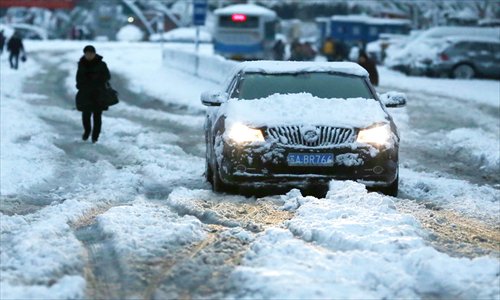 An unusually heavy, wet snowfall snarled traffic and confounded pedestrians in Nanjing, Jiangsu Province on Tuesday. Photo: CFP