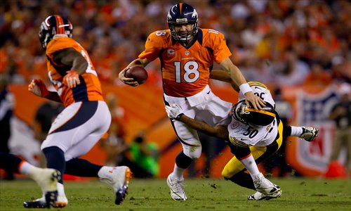 Peyton Manning (No.18) of the Denver Broncos stiff-arms Larry Foote (No.50) of the Pittsburgh Steelers. Photo: AFP