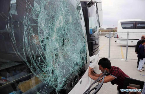 People check outside a destroyed bus at the parking area of the Sinan Erdem Arena in Istanbul, Sunday, May 13, 2012. About 300 Panathinaikos' basketball fans attacked the buses with Olympiakos' supporters. Photo: Xinhua