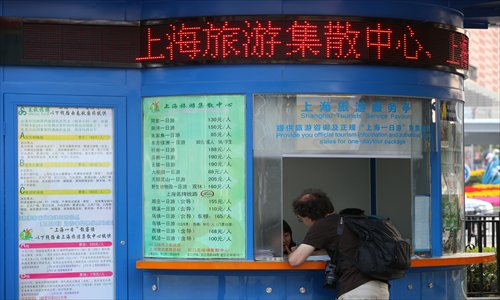 A visitor asks about city tours at a tourism service center at Lujiazui. Photo: Cai Xianmin/GT