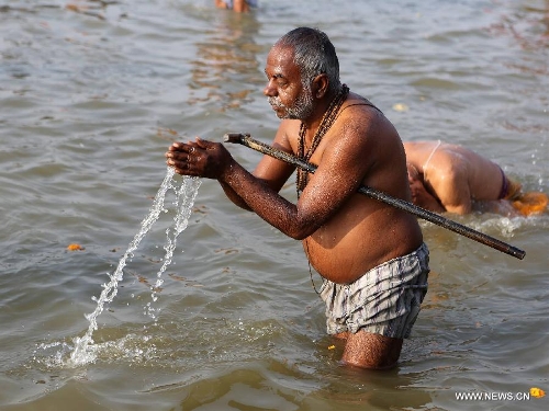 A Hindu devotee prays as taking bath in Triveni Sangam during Maha Kumbh Mela festival in Allahabad, a city in west uttar Predash, India, Jan. 27, 2013. (Xinhua/Li Yigang) 