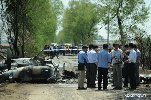 Investigators work beside the remains of a light plane after it failed to take off at Taoxian Airport in Shenyang, capital of northeast China's Liaoning Province, May 16, 2013. Three people on board were injured in the accident on Thursday. (Xinhua/Pan Yulong)