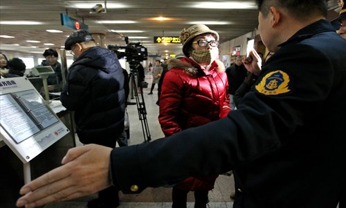 Officers stop a middle-aged woman at Zhongshan Park Station during a crackdown on fare dodgers Tuesday. The woman was caught using her mother's senior citizen pass to ride for free. Photo: Yang Hui/GT