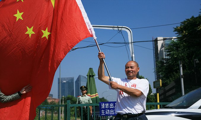 An activist holds up a Chinese flag outside the Japanese embassy in Beijing on Wednesday claiming sovereignty over the Diaoyu Islands. Photo: Guo Yingguang/GT