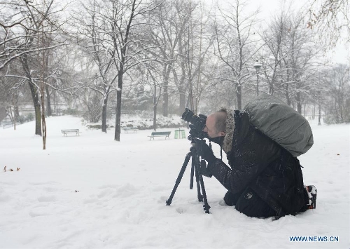 A man takes pictures in snow in Paris, France, Jan. 20, 2013. French weather agency Meteo France has put 55 departments, including the Ile-de-France (Paris and its suburb), under orange alert and decided to maintain the alert system in these areas till Sunday afternoon based on lasting snowfalls in these areas where the snow is expected to be thick as up to 20 centimeters. (Xinhua/Li Genxing)