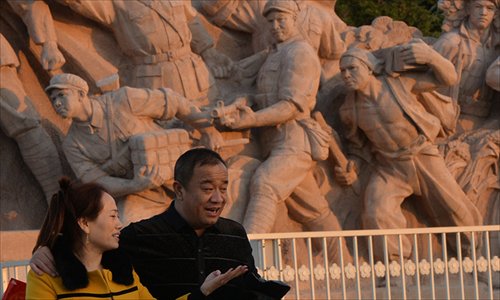 Tourists stand beside a revolutionary statue in Tiananmen Square after the Communist Party of China Central Committee concluded its Third Plenum in Beijing on Tuesday. A long-anticipated comprehensive reform plan was outlined after the meeting. Photo: AFP