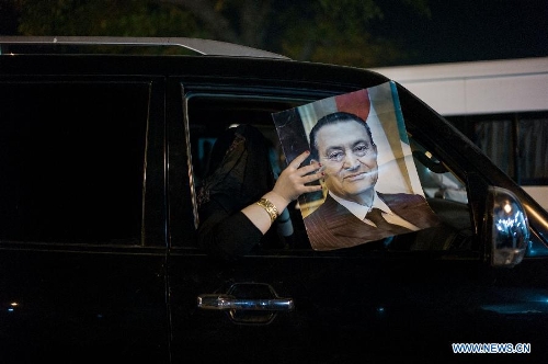A supporter of former Egyptian President Hosni Mubarak holds a poster during a protest outside the Maadi Military Hospital in Cairo, Egypt, April 17, 2013. Egypt's prosecution ordered Wednesday to discharge former Egyptian President Hosni Mubarak from Maadi Military Hospital and send him back to Tora Prison Hospital, official Al-Ahram news website reported. (Xinhua/Li Muzi) &nbsp;