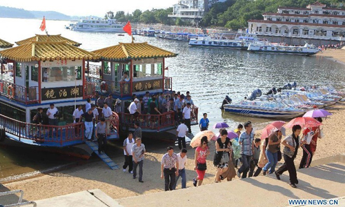 Visitors tour the Jingpo Lake in Mudanjiang, northeast China's Heilongjiang Province, July 7, 2012. About 30 percent more tourists have visited the Jingpo Lake scenic area this year than the same period last year, following a series of promotions. Photo: Xinhua