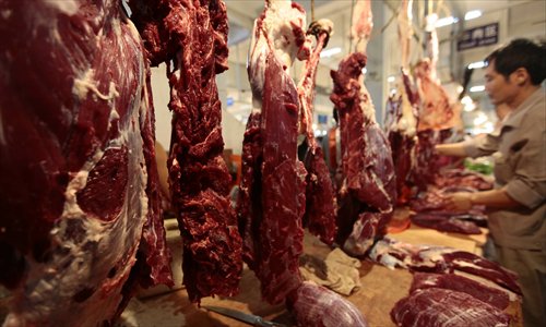 A worker slices beef at a market in Sanya, South China's Hainan Province Tuesday. The average price of beef was 35 percent higher Monday than the same time last year, according to a farm produce price monitoring index released by Xinhua Tuesday. Photo: CFP 