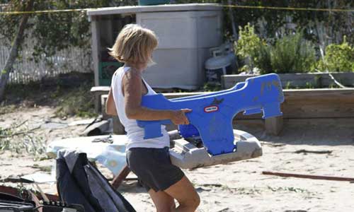 A woman clears debris after a tornado hit Rockaway peninsula of the borough of Queens, New York, the United States, Sept. 8, 2012. A tornado swept out of the sea and hit the beachfront neighborhood in New York on Saturday, hurling debris in the air and knocking out power. Photo: Xinhua