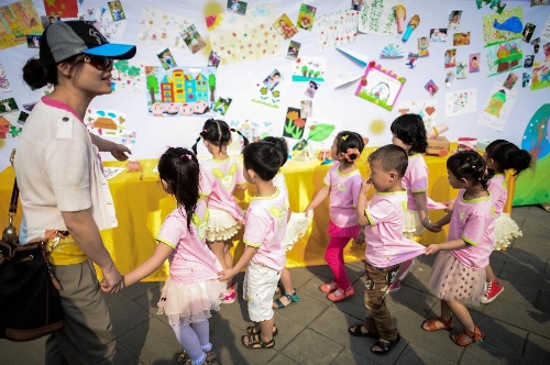 Children view their painting works at a birthday party at the Luohan Temple in Shifang City, southwest China's Sichuan Province, May 12, 2013. The children were born at the Luohan Temple five years ago after the devastating earthquake jolted Wenchuan County of Sichuan on May 12, 2008. The temple then was used as a temporary obstetrics hospital from May 13 to Aug. 7 in 2008 to deliver newborn babies. A total of 108 babies were born at the temple until the local maternal and child health care hospital reopened. (Xinhua/Jiang Hongjing) 