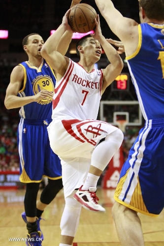 Jeremy Lin (C) of Houston Rockets goes to the basket during the NBA game against Golden State Warriors in Houston, the United States, on March 17, 2013. (Xinhua/Song Qiong)