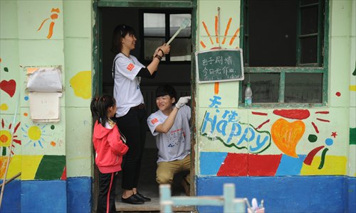 Volunteers help paint classroom walls at Tongxin Experimental Primary School, a migrant school in Chaoyang district, on April 20. The school faces closure due to safety code violations. Photo: CFP