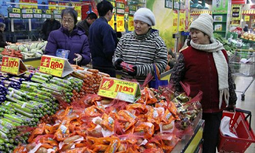 Consumers buy goods at a supermarket in Handan, north China's Hebei Province, December 9, 2012. China's consumer price index (CPI), a main gauge of inflation, grew 2 percent year on year in November, the National Bureau of Statistics announced Sunday. The inflation rate increased from a 33-month low of 1.7 percent in October as food prices increased. Photo: Xinhua