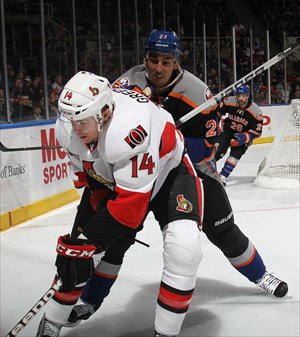 Colin Greening (No.14) of the Ottawa Senators is checked by Milan Jurcina of the New York Islanders. Photo: AFP